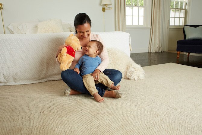 Baby and mom playing with teddy bear