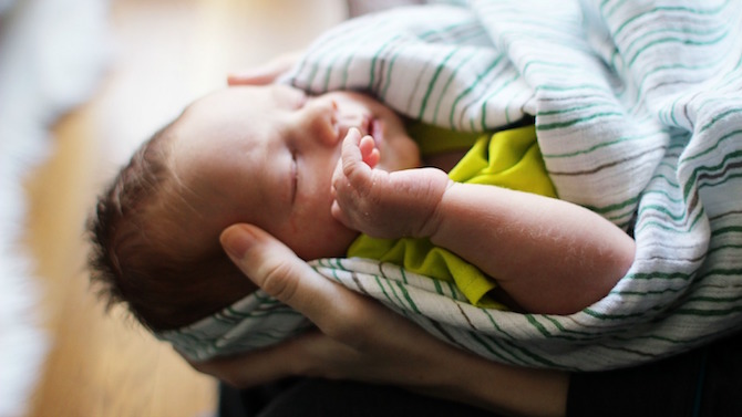 Baby sleeping in parent's hands