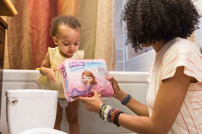 Mommy handing training pants to baby in order to start transition