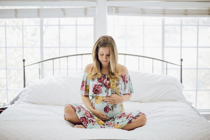 Mom waiting patiently on bed holding her belly