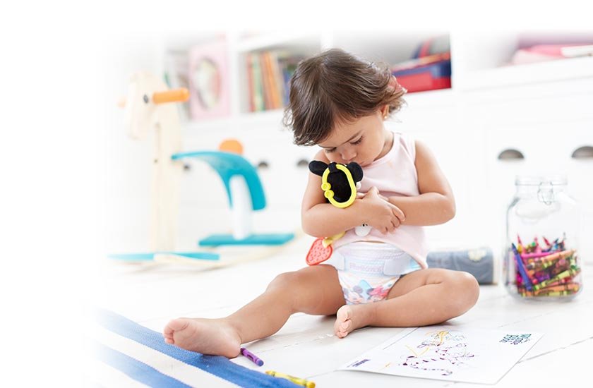 Toddler playing with Mickey Mouse on the floor