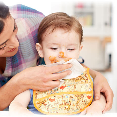 Mom wiping baby's mouth after mealtime