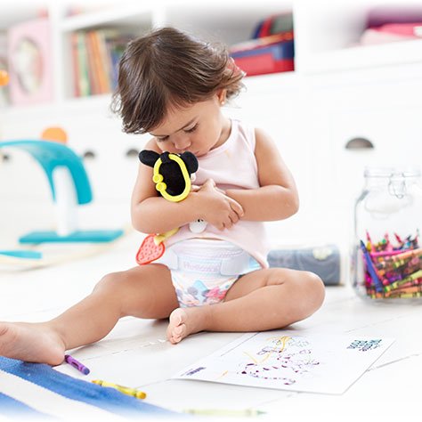 Toddler playing with Mickey Mouse on the floor