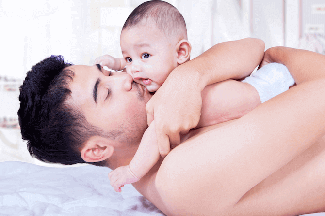 Dad hugging baby skin to skin